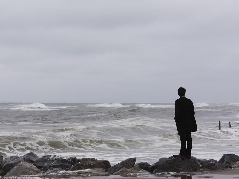 A man standing alone on the sea shore_Photo by: Eexistentialcrisiss